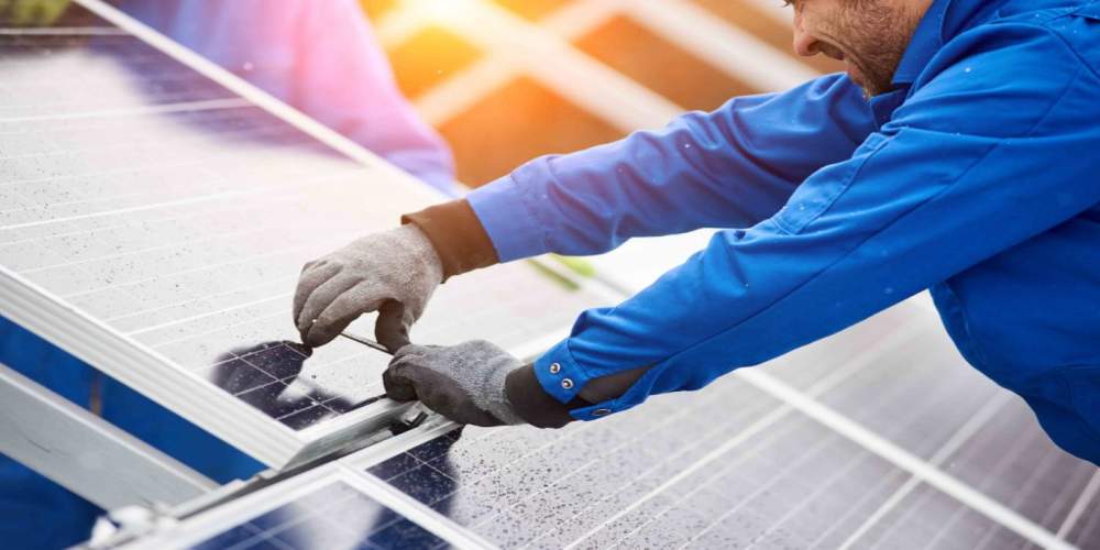 Man installing solar panels on a roof